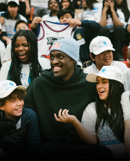 Pascal Siakam sitting with a group of kids.